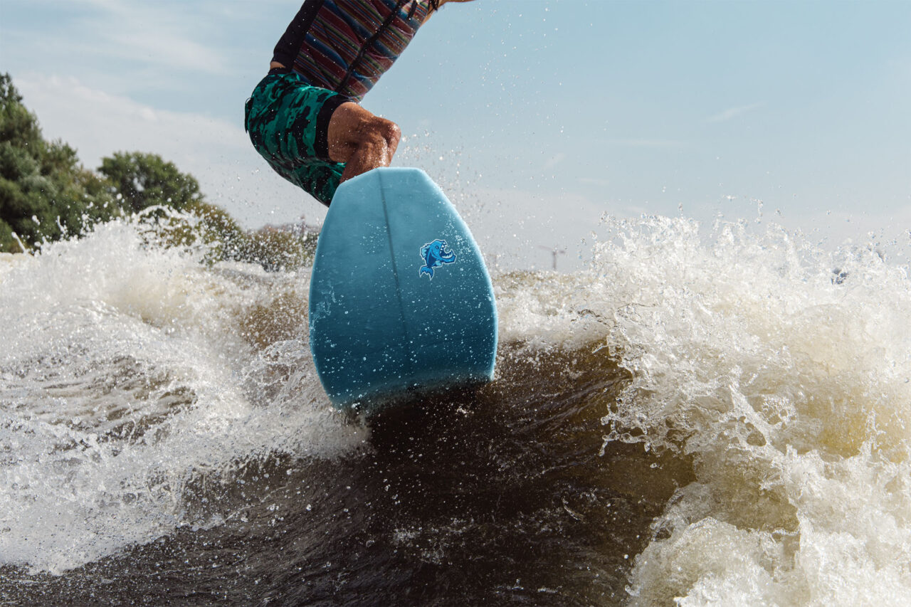 Illustration Case: Mockup Wakeboard auf Wasser mit Piranha-Icon in Blau fuer Blue Sky Surfing